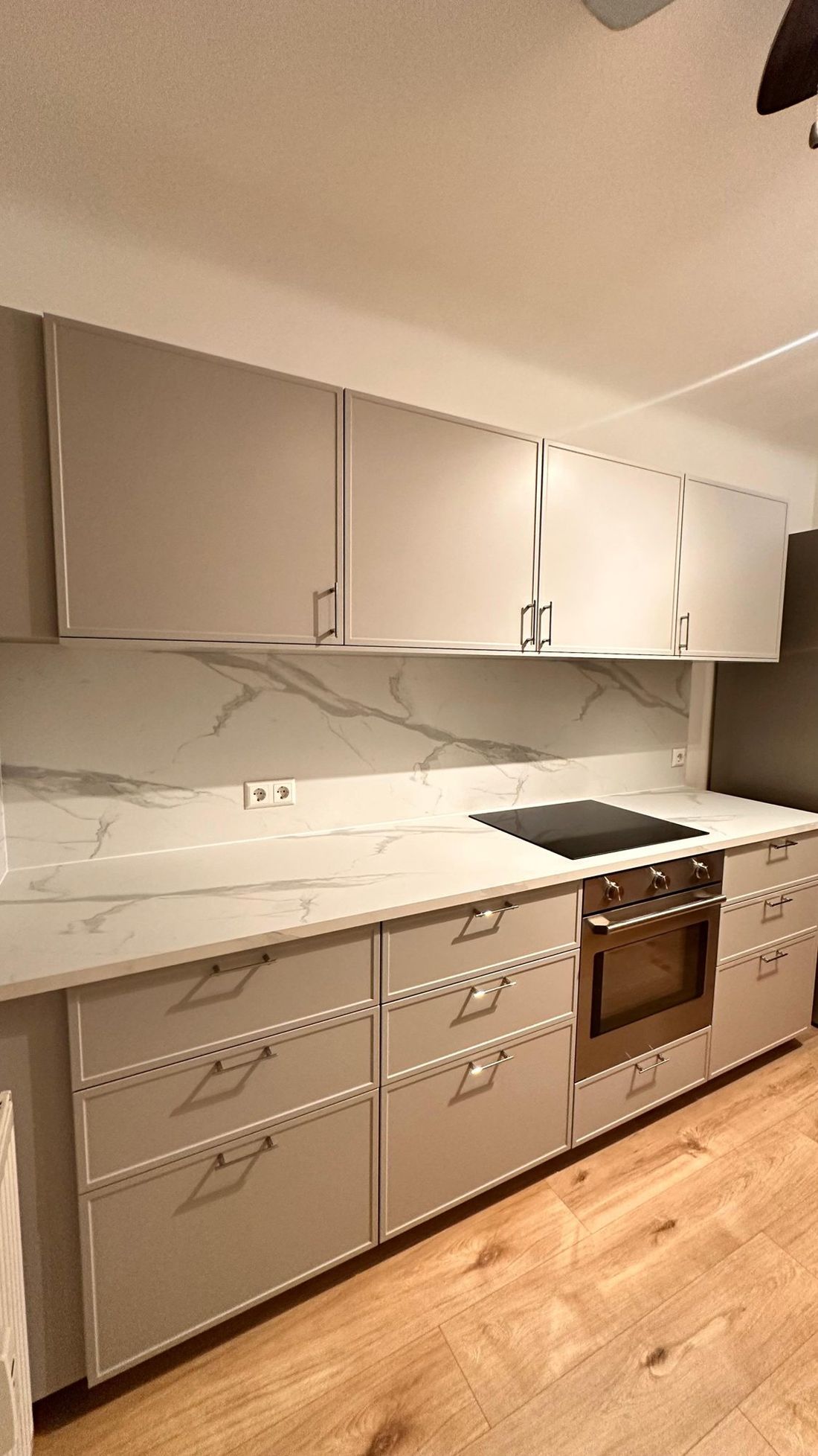 Graue Küche mit Rahmenfronten, Marmorrückwand und Backofen