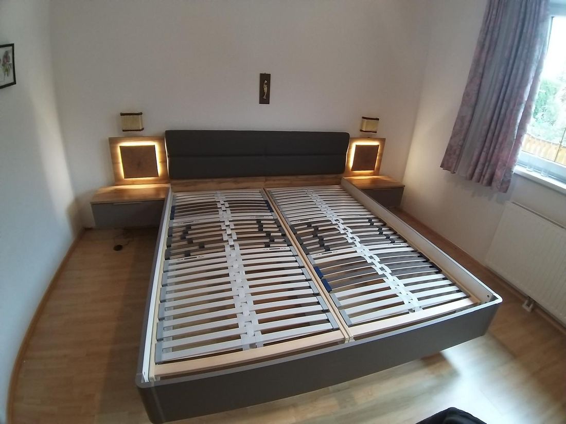 Doppelbett mit beleuchteten Nachtkästchen