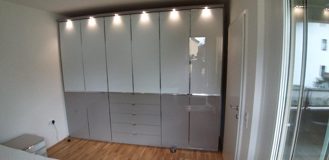Kleiderschrank mit Glasfronten und Kranzbeleuchtung